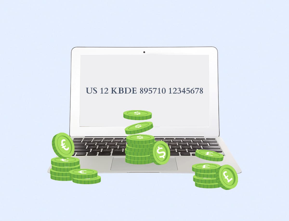 Computadora portátil abierta con una pantalla que muestra un código IBAN rodeado de pilas de monedas verdes con símbolos de moneda sobre el teclado, ilustrando una transacción financiera o detalles de una cuenta bancaria.