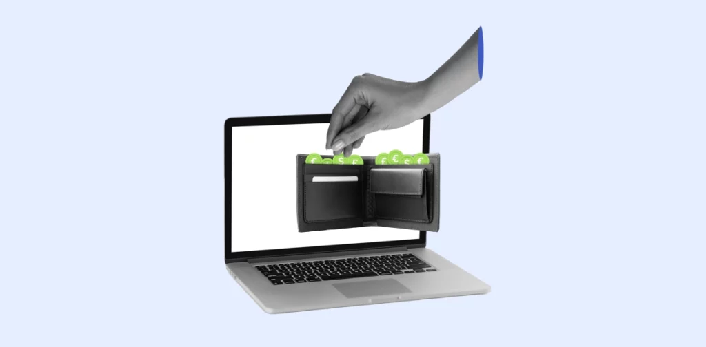 Laptop con cartera negra afuera con monedas verdes saliendo mientras una mano las están tomando. 