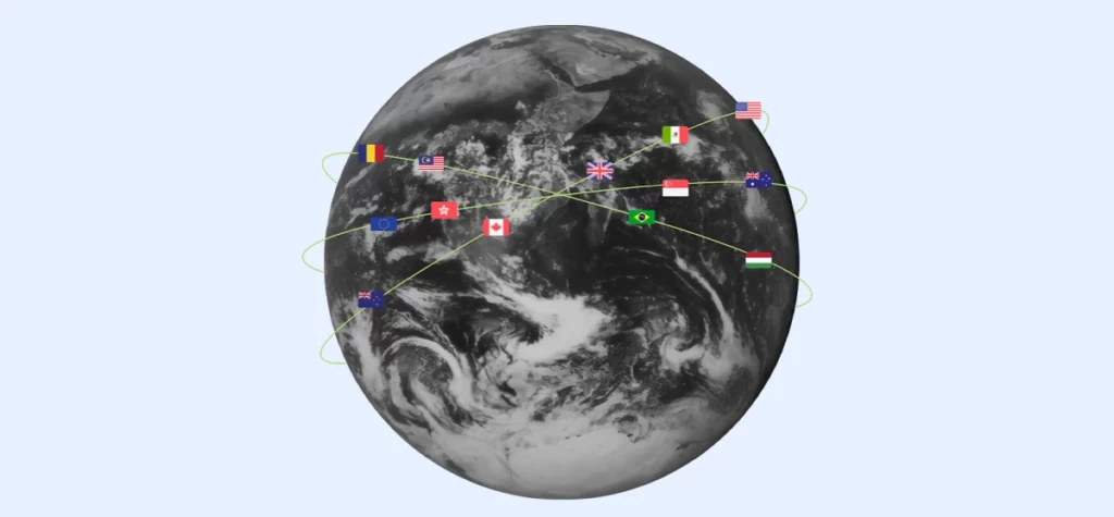 A monochromatic globe with flags from different countries revolving around it. 