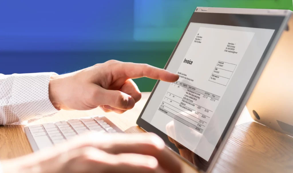 A person holding a tablet that displays an invoice with the word "Invoice" and the company logo at the top.
