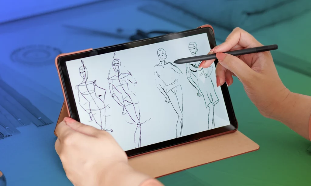 A designer’s hands holding a stylus and drawing on a digital tablet, which displays sketches of fashion figures, illustrating the modern process of digital fashion design and conceptualization.