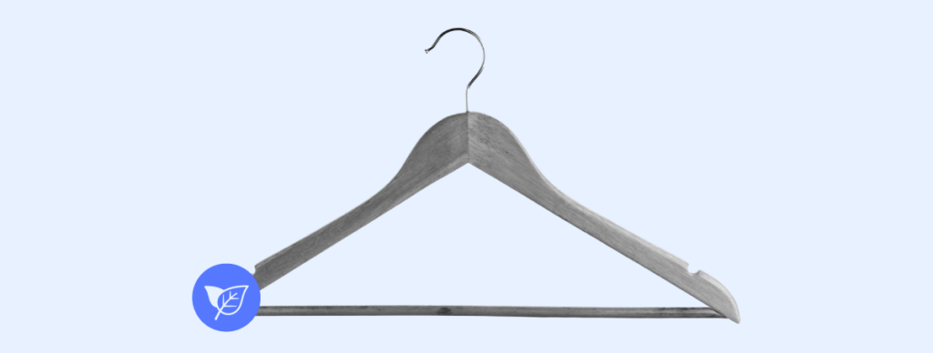 A  wooden clothes hanger, featuring a blue logo of a leaf on a circular tag, symbolizing sustainable fashion.