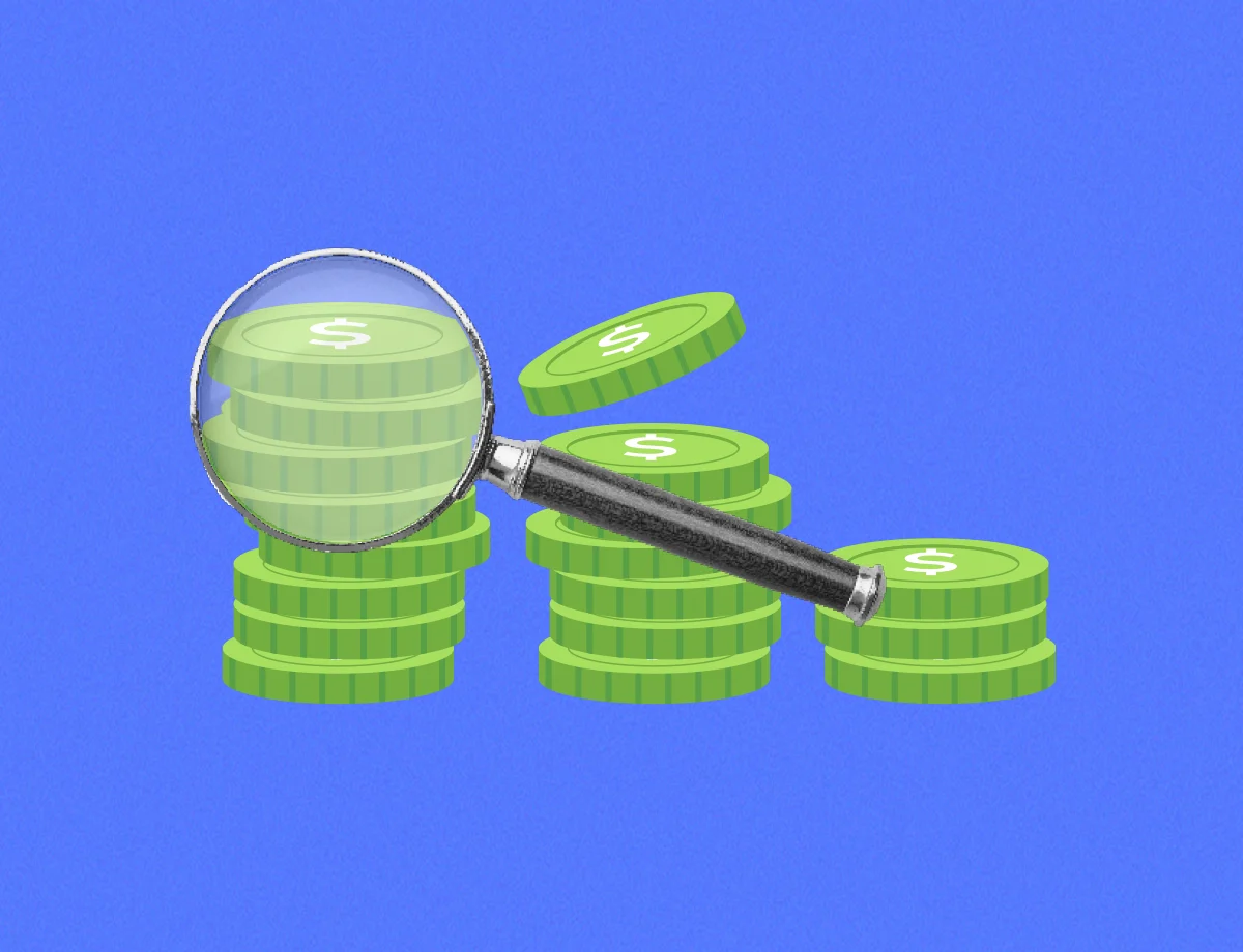 A stack of green coins being inspected by a magnifying glass.
