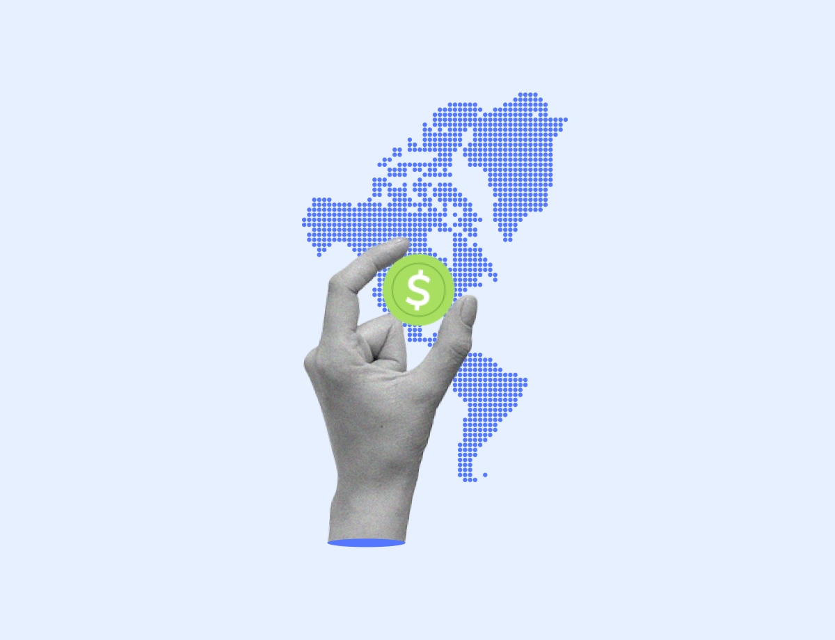 Mano sosteniendo una moneda de dólar sobre un fondo con un mapa del mundo digitalizado en tonos azules, simbolizando la influencia de la tecnología en la economía global y las finanzas digitales.