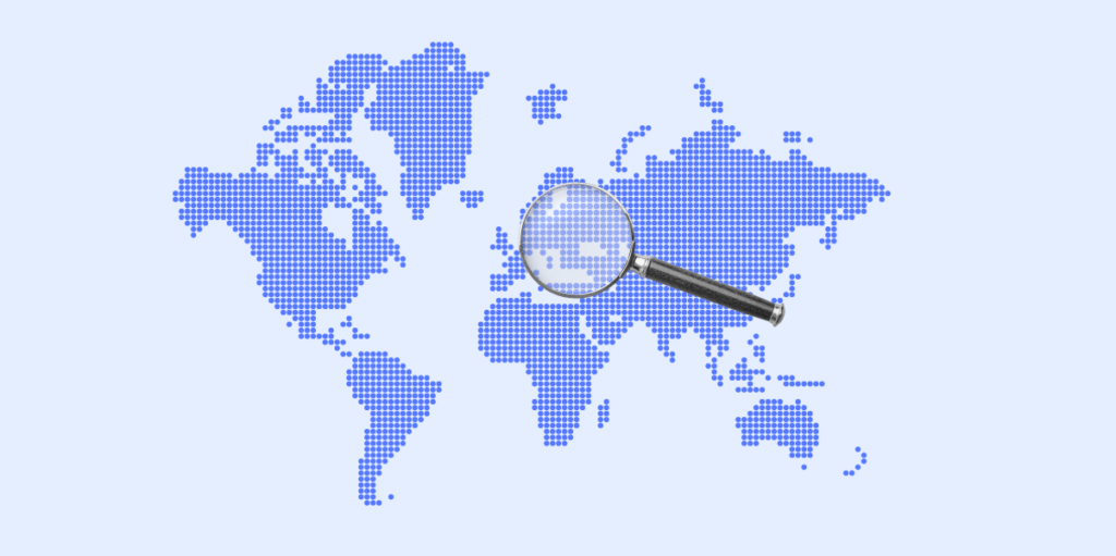 A blue dotted map of the world being viewed by a magnifying glass.